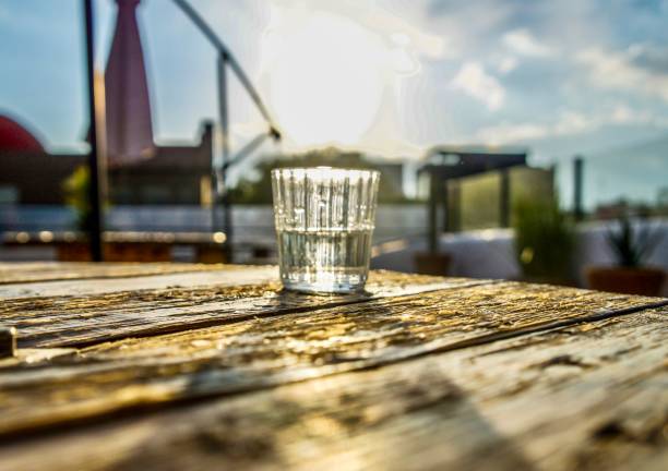 Glass of water on a sunlit table representing mindful hydration